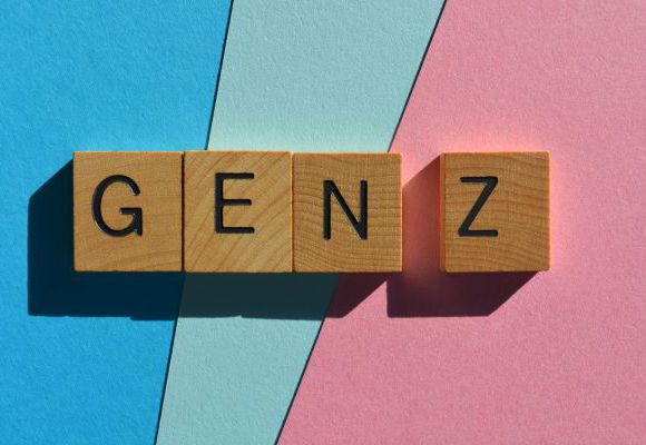 wooden tiles with the letters GEN Z against a colorful blue and pink background 