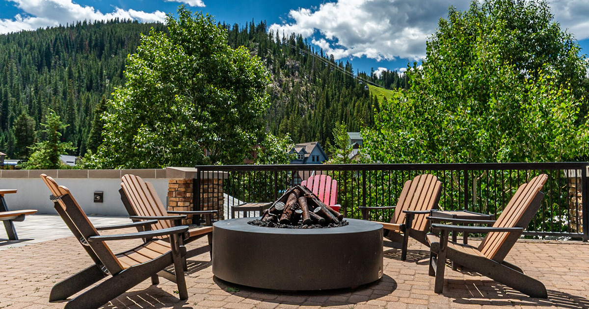 Fire pit and lounge chairs in front of mountain at Winter Park.