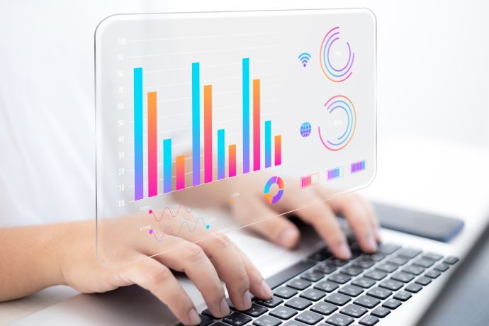 hands typing on a keyboard while a bar chart illustration is shown above