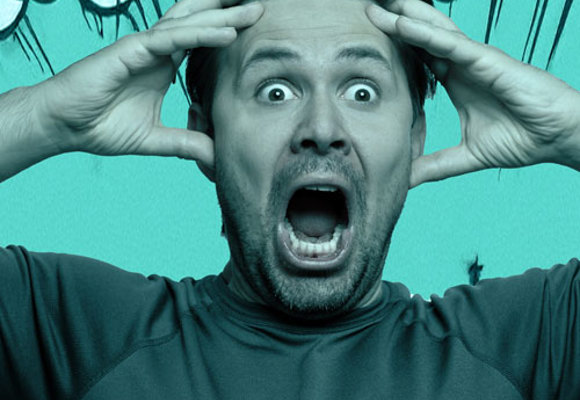 Man holding head and screaming.