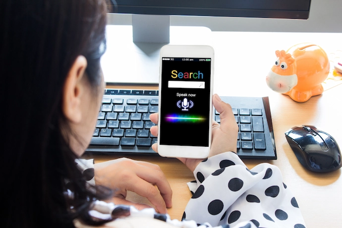 Woman using the voice function on her phone to perform a web search