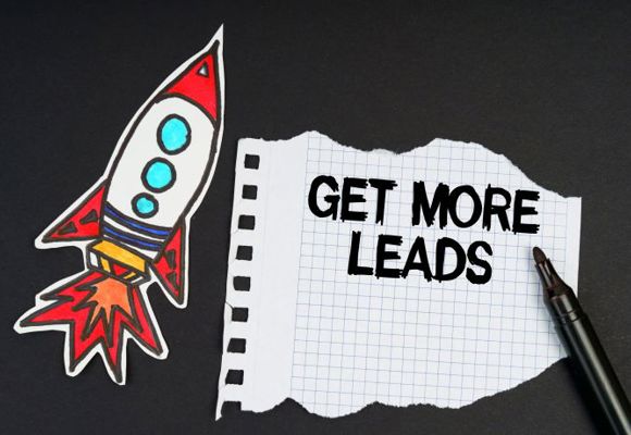  On a black background, a rocket, a marker and paper with the inscription - GET MORE LEADS