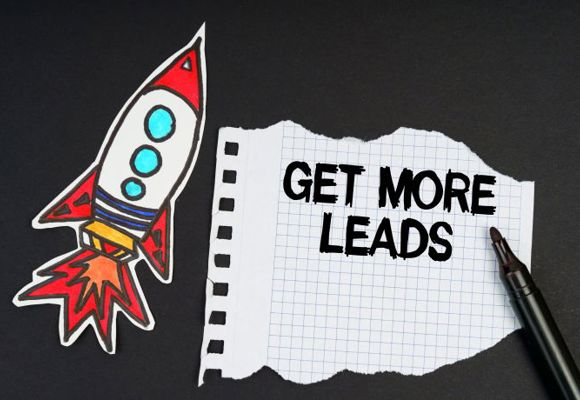 On a black background, a rocket, a marker and paper with the inscription - GET MORE LEADS